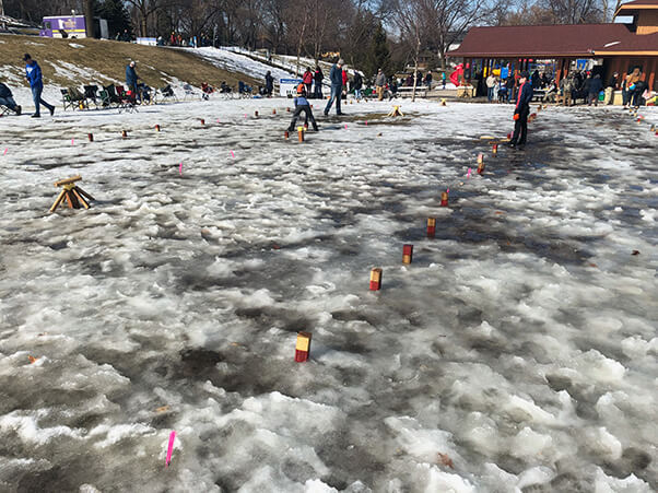 Photo of kubb being played in melting snow.